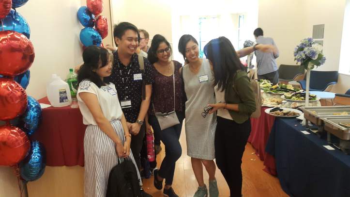 Five people standing in a room with balloons on the left wall and food on the right side of the photos